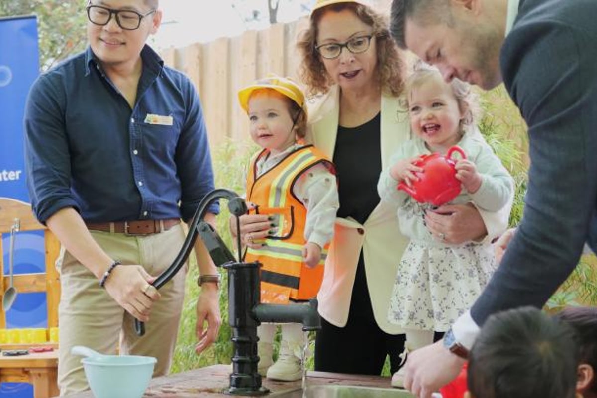 Toddlers assist local member Sonja Terpstra and Melbourne Water Head of Service Enablement One Water Sean Hanrahan with the water pump at an early learning centre in Croydon. Image: Melbourne Water