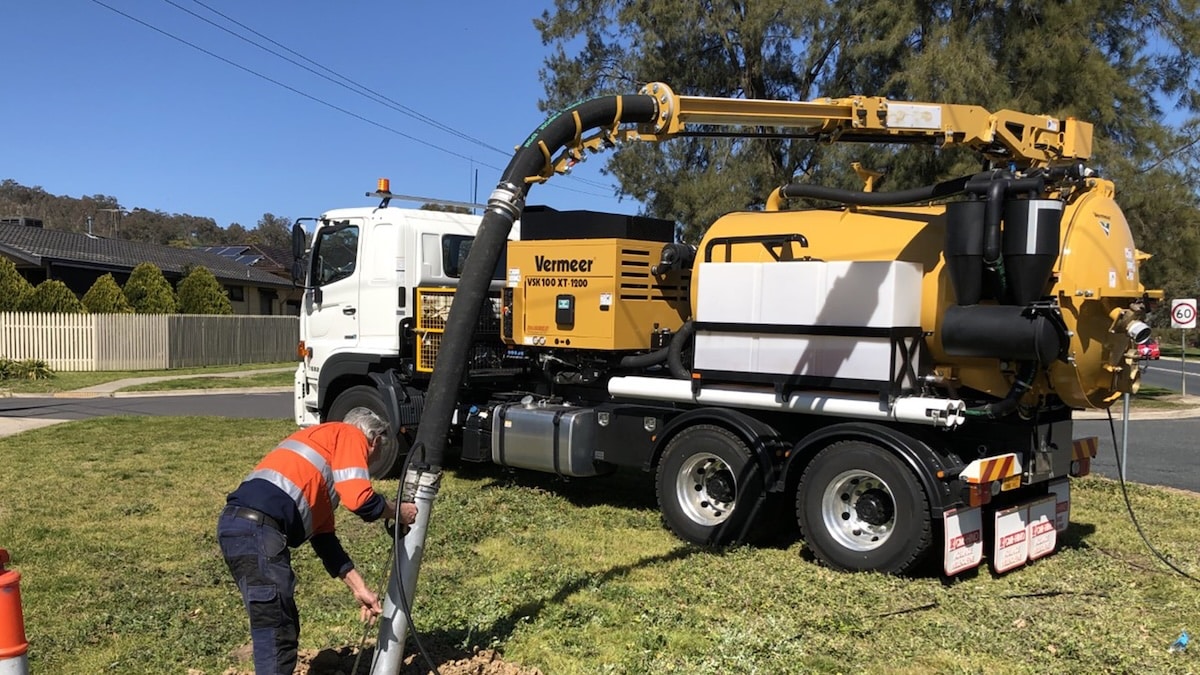 A worker readies a vacuum underground solution on a council project.