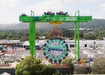 A giant gantry lowers a TBM cutterhead into the launch box.