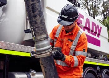 A technician from Ready Group secures a hose for vacuum excavation.