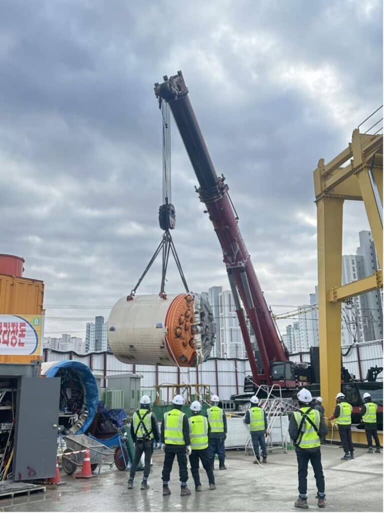 A crane lowers part of the 135m long TBM on site.