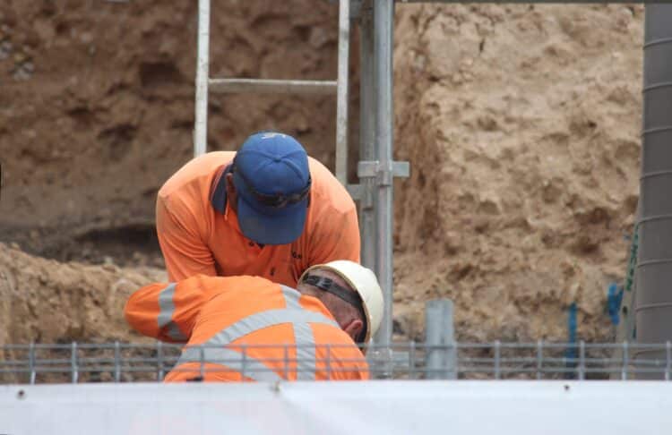 Construction workers in Sydney above an excavation pit.